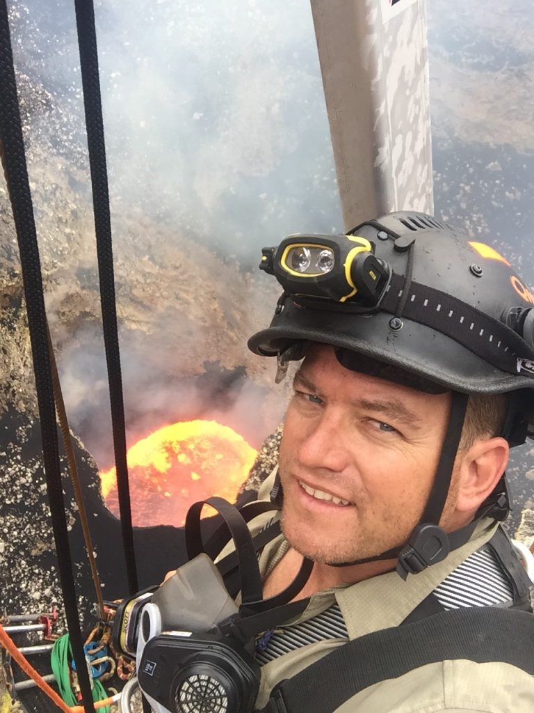 Mike Thompson avec casque et baudrier, au-dessus du lac de lave d'un volcan
